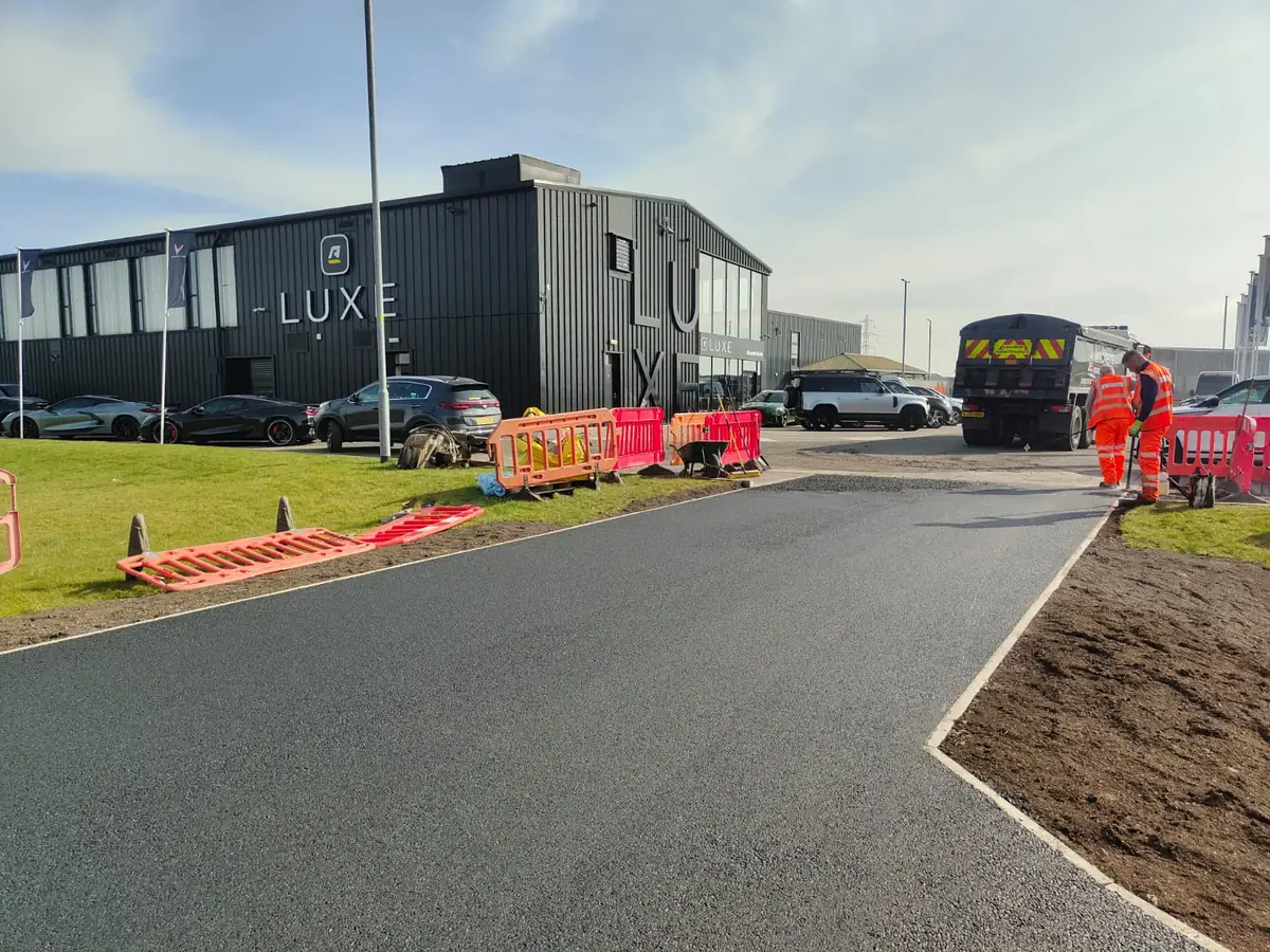 Groundworks crew excavating and preparing a sub-base for a new driveway in Scotland